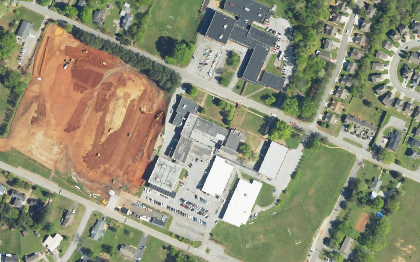 The Tyner Middle High Academy campus on Tyner Road, with cleared ground beside the school buildings, seen from the air.